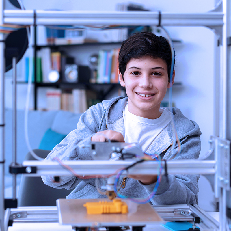 Smart young boy learning how to use a 3D printer at home, science and technology concept