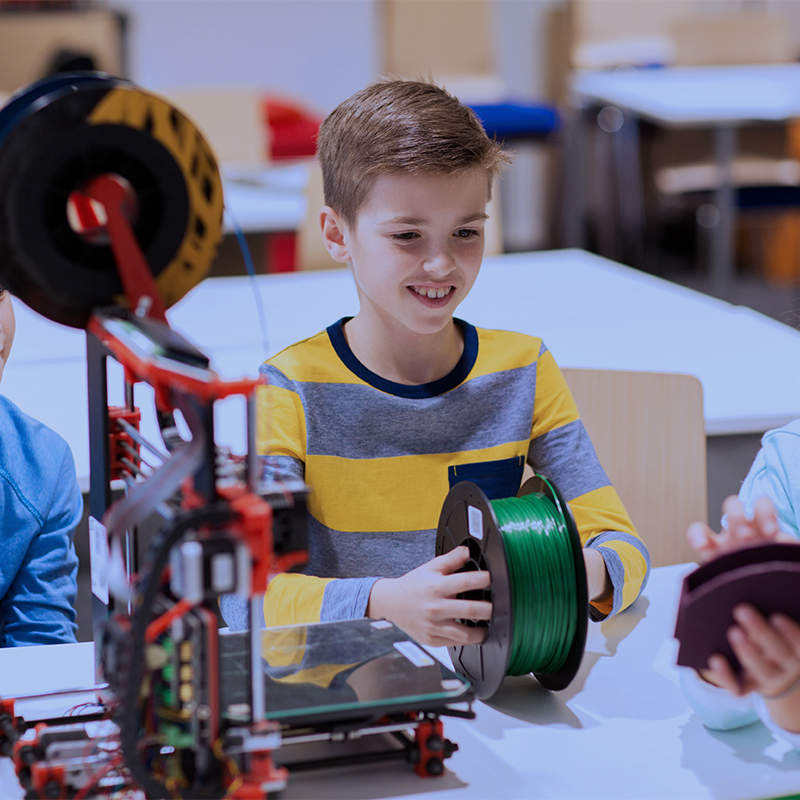 Grupo de niños felices con una impresora 3D en la clase de robótica