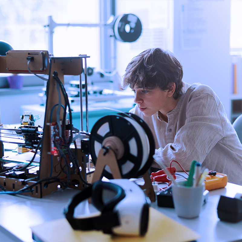 Estudiante usando una impresora 3D en el laboratorio